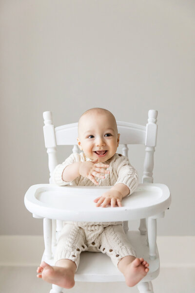 baby boy laughing in high chair