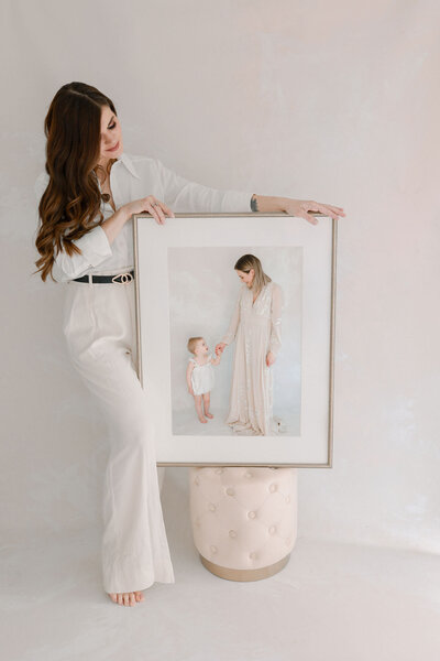 Familien- und Babyfotografin Josephine Böck präsentiert ein großes gerahmtes Familienportrait mit Mama und Baby.