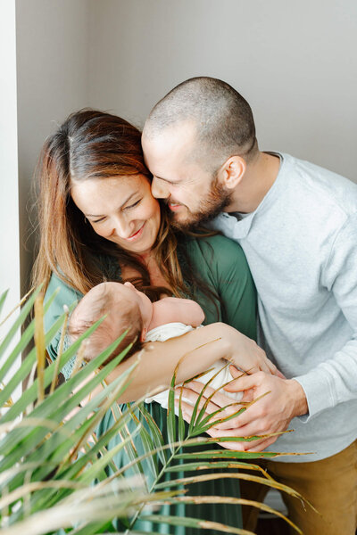 Dad kisses Mom on the cheek during their newborn session with Toronto Newborn Photographer