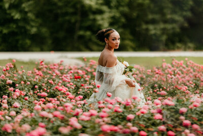bride posing in field of pink flowers