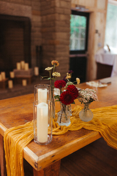 Flowers and candle on table where brides will be sitting