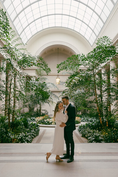 bride and groom embracing in atrium