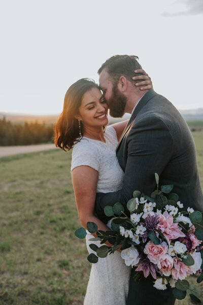 Sacramento Wedding Photographers capture bride laughing while groom kisses cheek