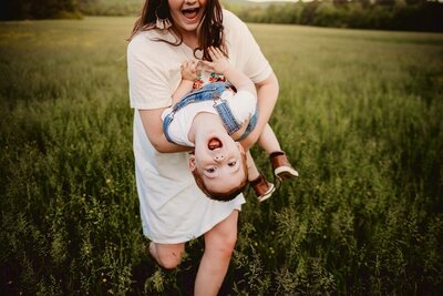 photo of little boy being hung upside down by his mom