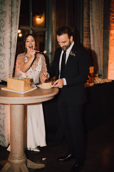 Bride and groom cut cheese shaped cake
