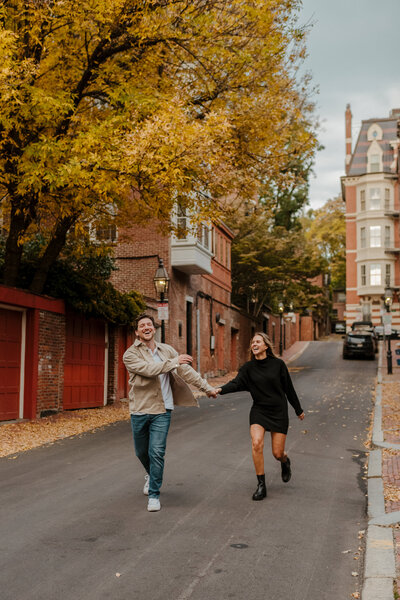 candid photo of a man and woman at their engagement session in beacon hill of boston