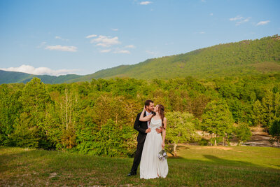 photo of bride and groom  in front of a mountain background