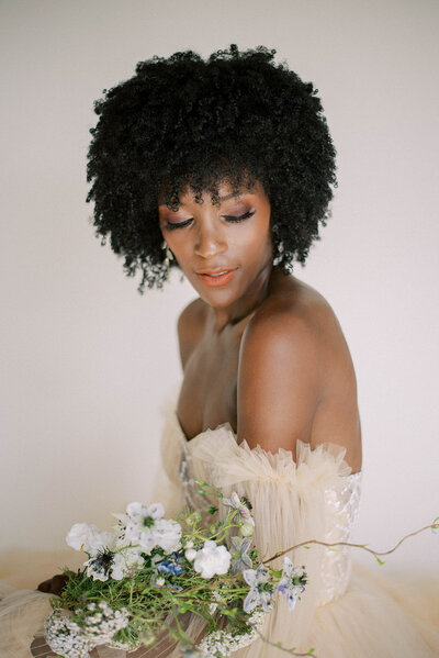 stunning bride holding onto a whimsical  wedding bouquet as she looks down