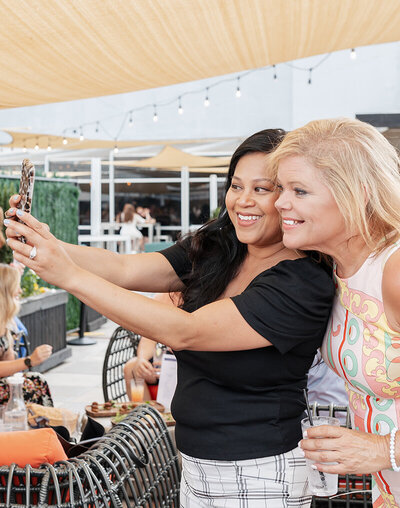 Women taking a selfie outdoors at an event