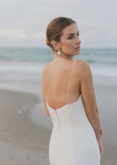 Model with hair and makeup done standing on Beach in Tauranga