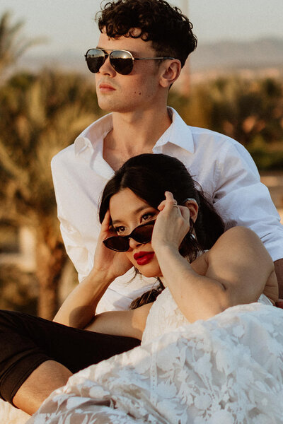 bride and groom with sunglasses watching sunset