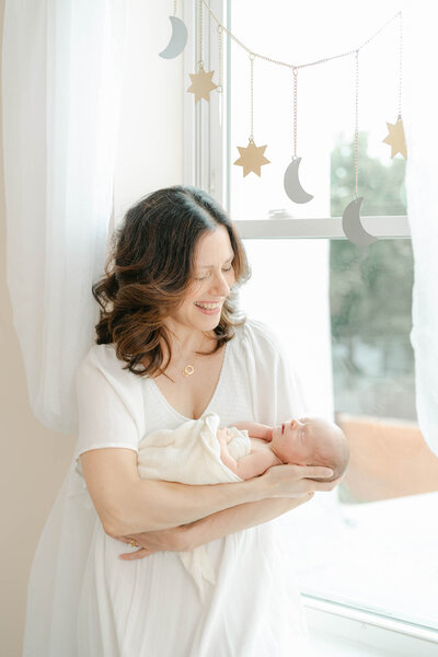 Philly mom holds her newborn baby during her photo session with AnneMarie Hamant
