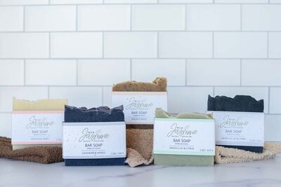 five handmade soaps front facing the camera in front of a bathroom tile