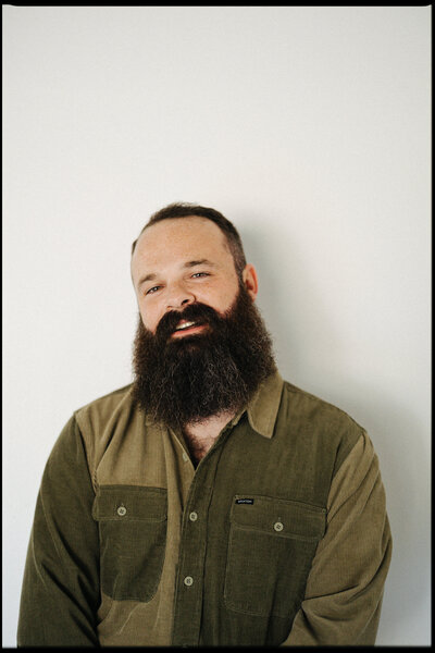 Photographer Jake Ford smiling with a film camera at Haus 820 wedding venue in Lakeland, Florida.