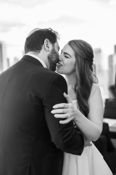 Black and white photo of bride and groom kissing