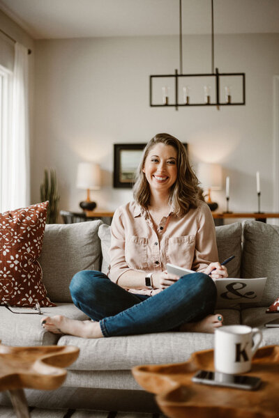 Smiling woman sitting cross-legged on a couch