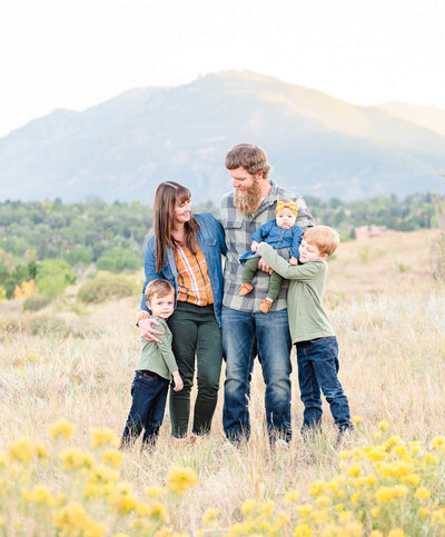 A family of five poses during an outdoor family photography session in the mountains.