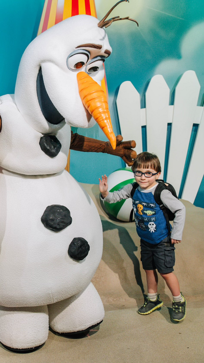 A young boy meets Olaf at Disney World