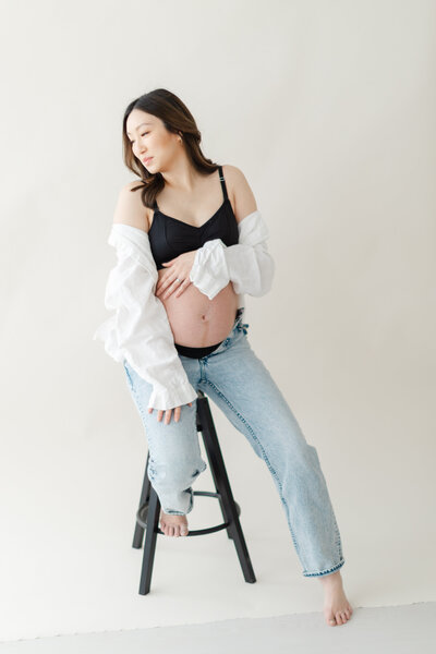 Pregnant woman poses for maternity portrait in photography studio