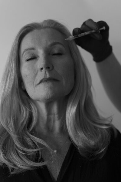 Black and white of woman receiving botox on her face