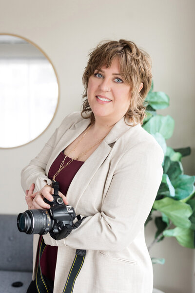 Tara holding a camera smiling