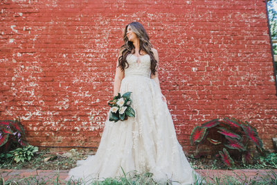 bride in front of a red brick wall
