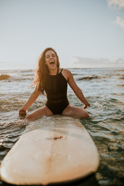 girl smiling on surf board in ocean