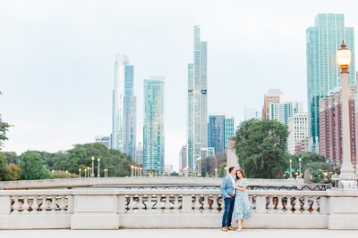 Couple posing by Lake Michigan with the Chicago skyline behind them