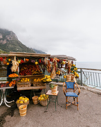 fruit stand with lemons and oranges and blue chair