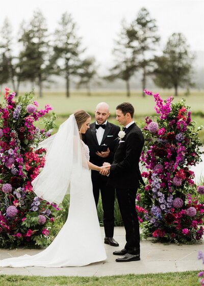 Wedding ceremony at Sunriver Resort with purple floral pillars