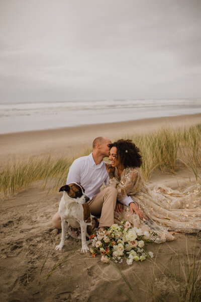 couple with dog on beach in oregon