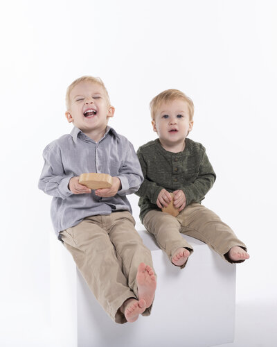 Charlotte brothers one laughing smiling at the camera on a white background, created in our Fort Mill SC portrait studio