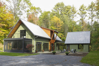 Outside view of mountain home with green paint and wood finishes