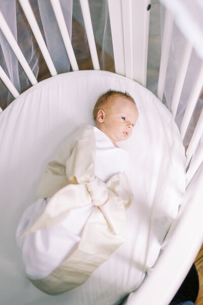 Newborn baby laying in bassinet