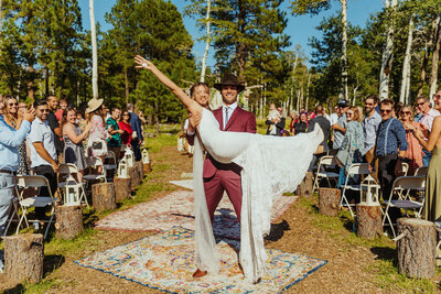 couple cheering as they walk down the isle after getting married in flagstaff
