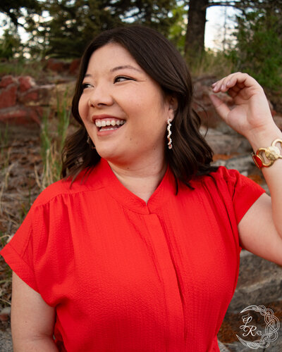photo of Ashlyn sitting on a rock with her arms spread and legs pointed straight in front of her
