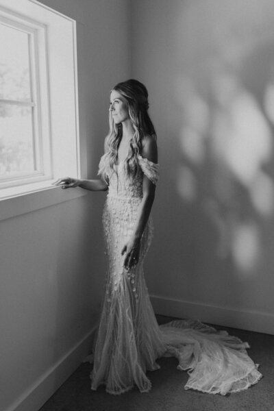 black and white image bride looking out window