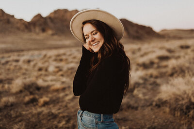 woman smiling wearing a hat