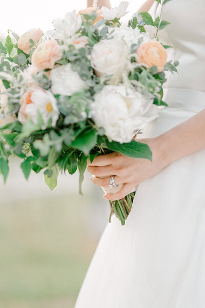 Image of a peach and white bridal bouquet on a wedding day.