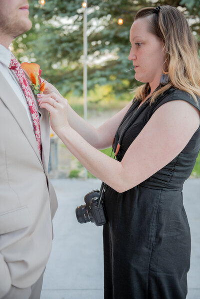 Seattle Wedding Coordinator adjusting groom's boutainniere