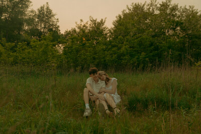 Man and woman romantically spin around, laughing in the middle of a  flowery field