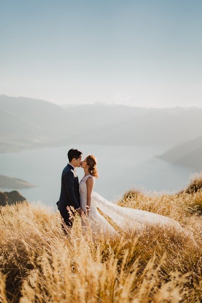 Bride and groom in the long grass above lake wakatipu
