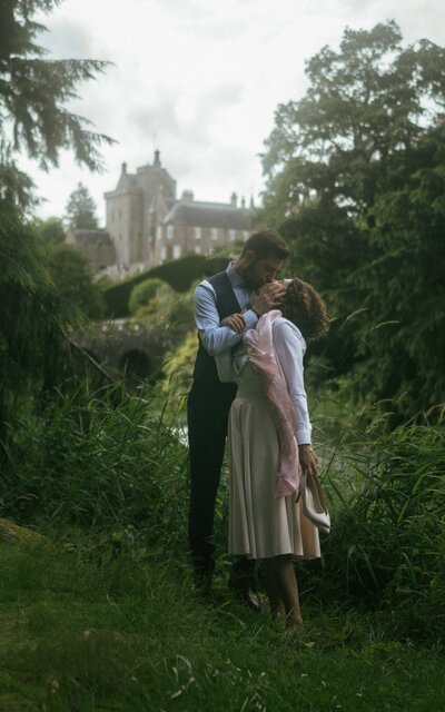 Beautiful couple sharing a passionate kiss while standing together, capturing a moment of love and connection on their special day