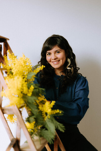 Portrait de la photographe Camila Garcia avec du mimosa