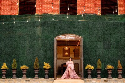 on location maternity session with a mother to be dressed in a rose pink at the providence cotton mill in charlotte, nc