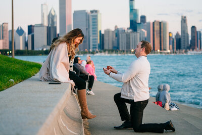 Man proposing to girlfriend at Adler Planetarium, with Lake Michigan and the Chicago Skyline in the background