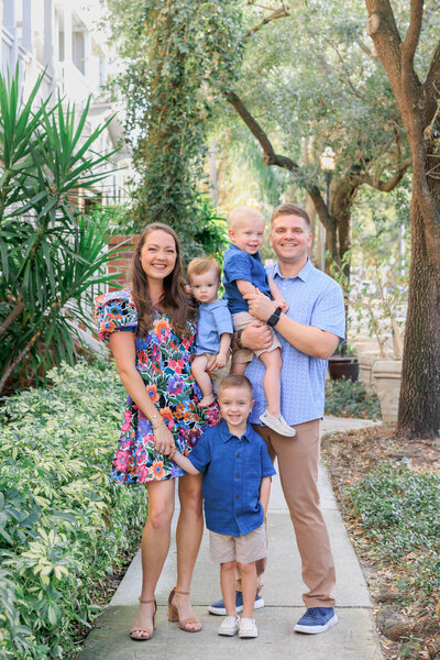 Mom and Dad with their kids pose on the sidewalk of Hyde Park Village in Tampa, FL.