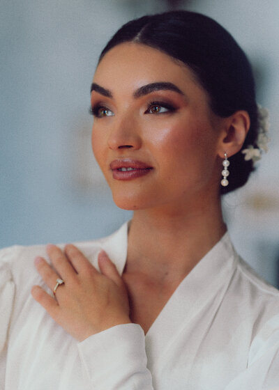 Elegant modern bride striking a pose, showcasing her stunning wedding dress and radiating confidence in a stylish, intimate setting