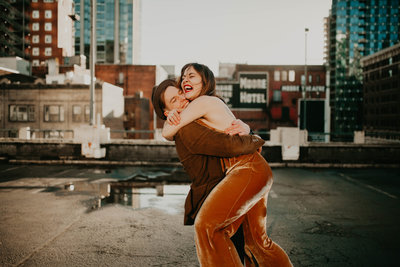 Woman hugs her fiance on a Seattle rooftop during their engagement photography session