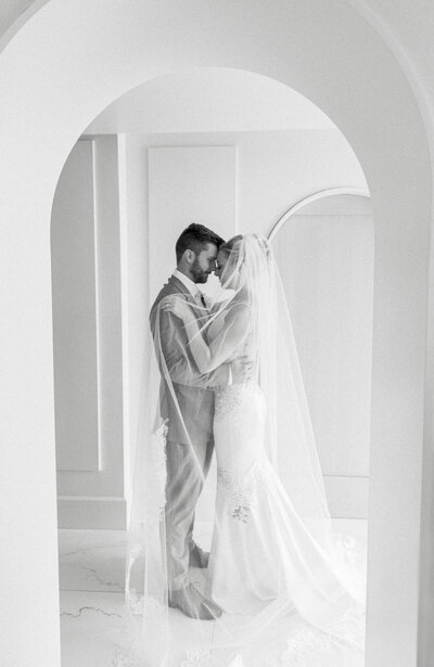 Wedding Photographer, abride and groom embrace inside a home
